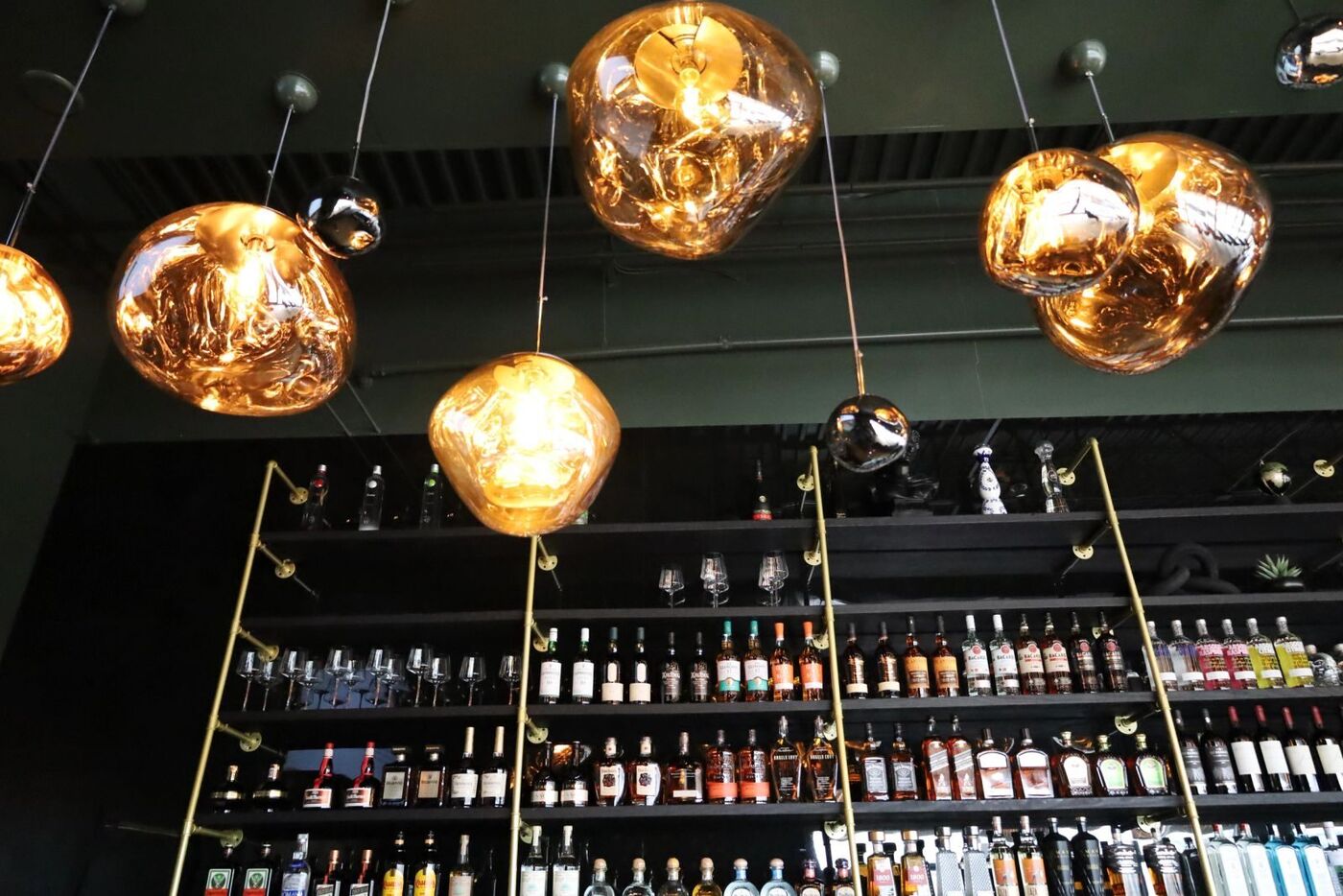 Olé's back bar under amber pendants