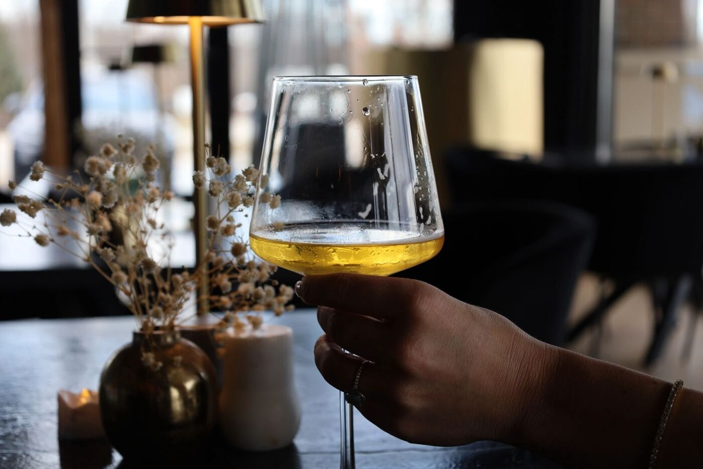 A glass raised at a candlelit table